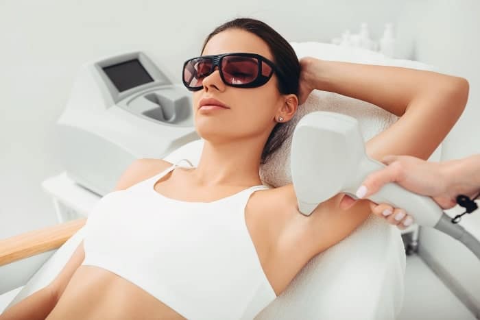 Client receiving professional laser hair removal treatment to reduce unwanted hair and improve skin smoothness