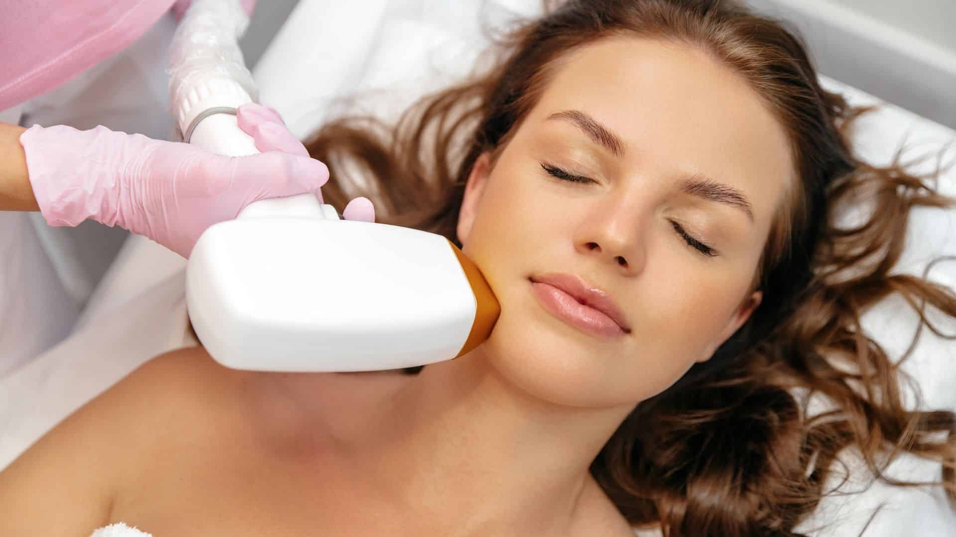 Woman receiving facial laser hair removal treatment on the chin at a Vancouver medical aesthetics clinic for long-lasting hair reduction.